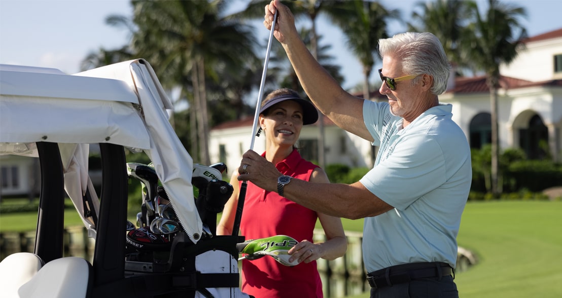 Sailfish Point Golf Equipment man and woman putting golf club back into the golf cart at sailfish